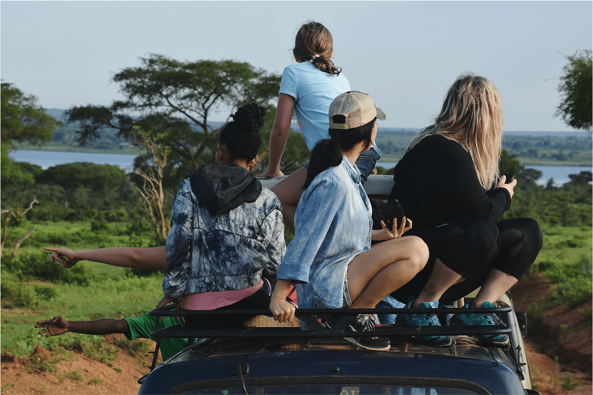 Mujer sentada en un vehículo de safari mirando el paisaje